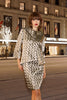 Woman in a patterned outfit standing in front of a hotel at night.