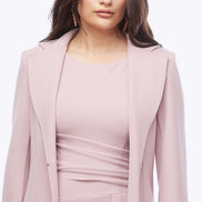 Woman wearing a pink dress with a matching jacket on a white background