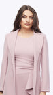 Woman wearing a pink dress with a matching jacket on a white background