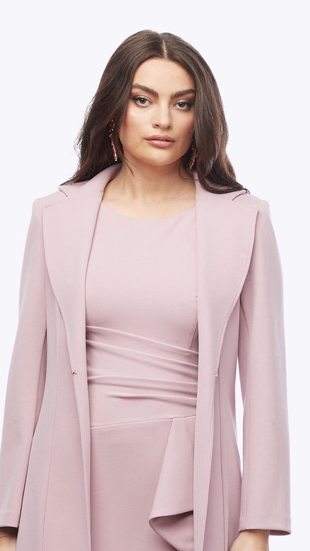 Woman wearing a pink dress with a matching jacket on a white background