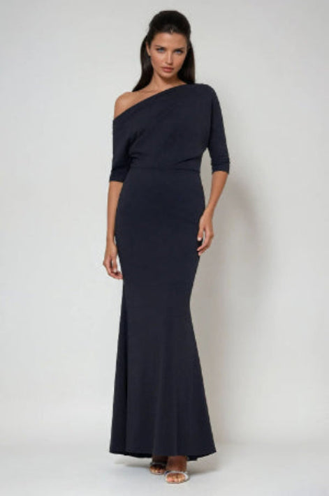 Woman wearing a black one-shoulder dress against a white background
