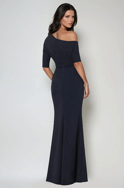 Woman wearing a navy off-shoulder gown against a white background
