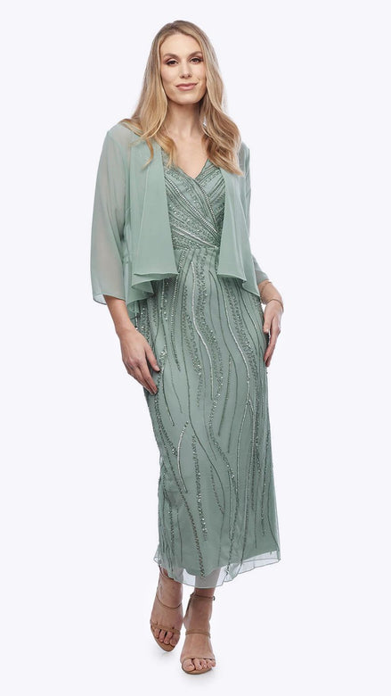 Woman wearing a green dress with a matching jacket on a white background