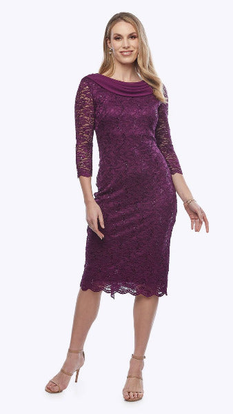 A woman in a purple stretch sequin lace dress with a chiffon shawl cascading down the back, featuring a cowl neckline and three-quarter sleeves.