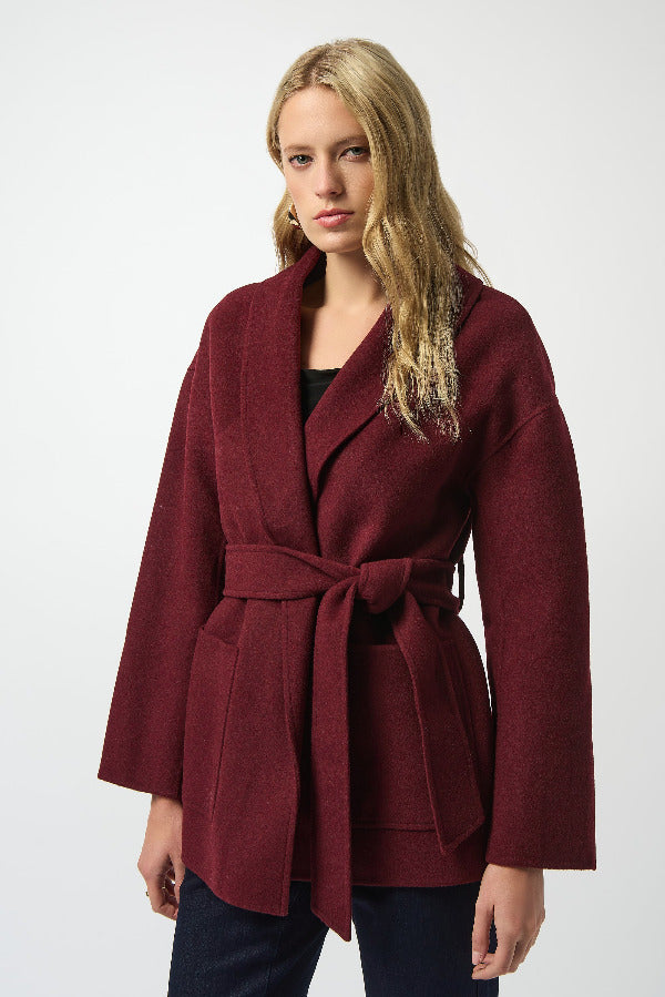 Woman wearing a burgundy coat with a white background