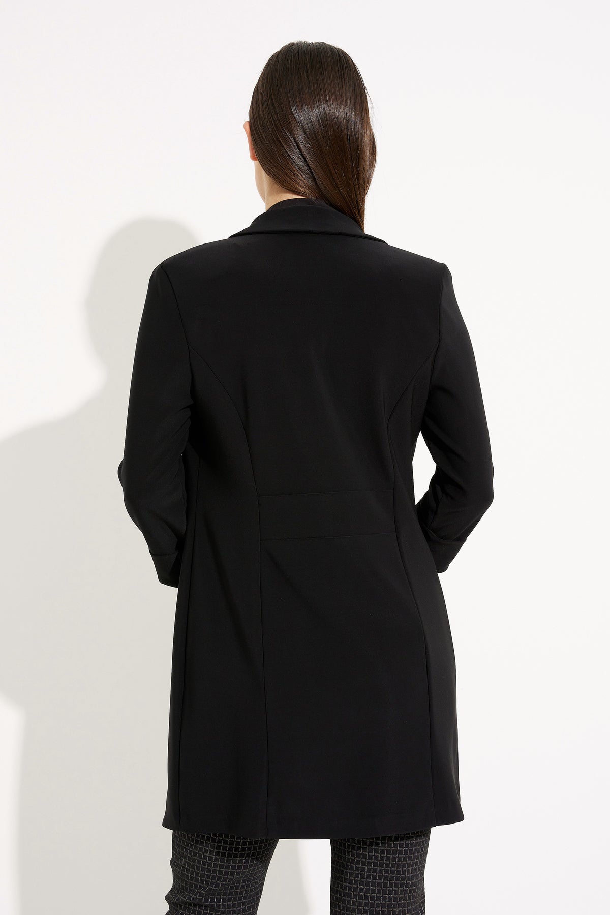 Person wearing a black coat on a white background