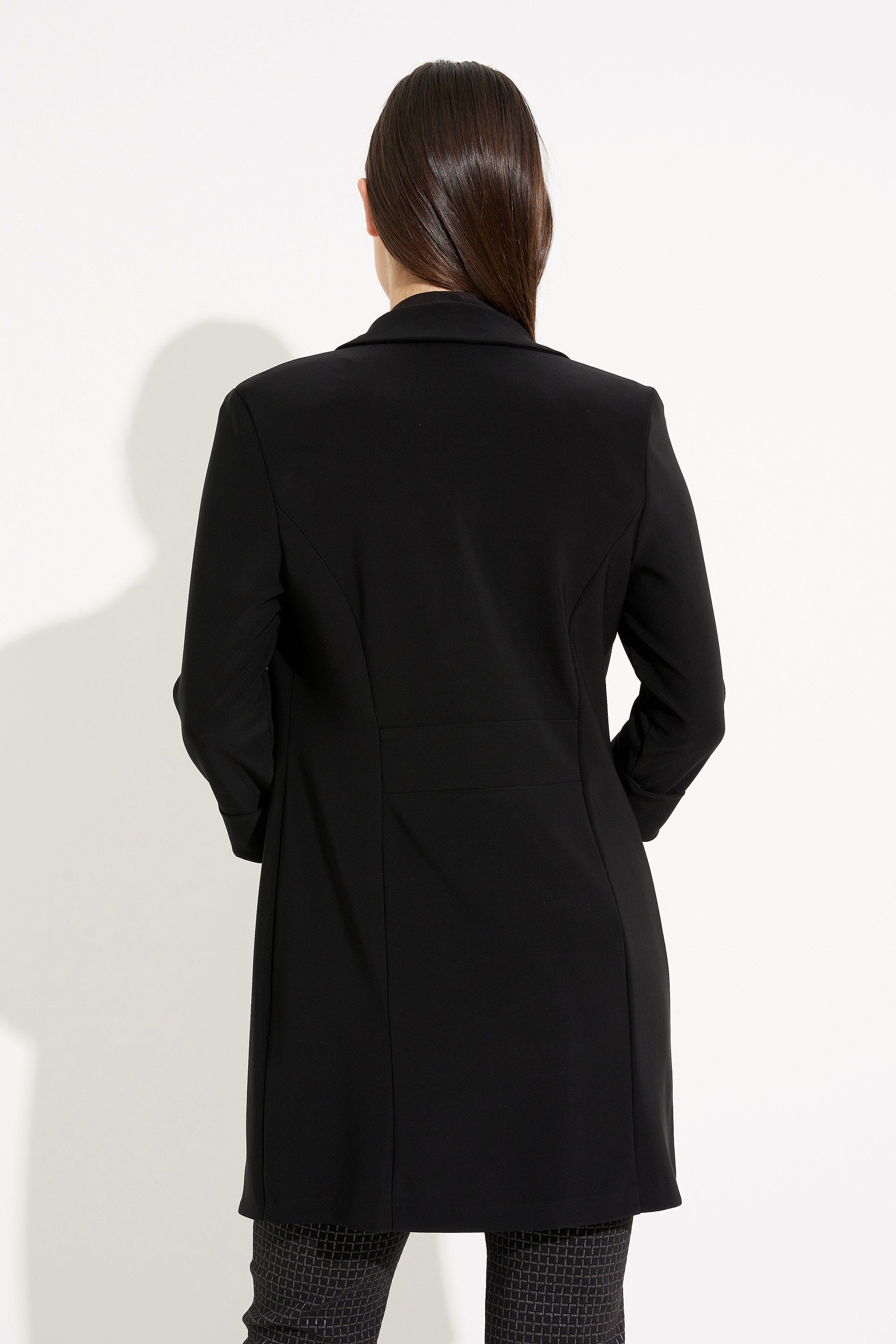 Person wearing a black coat on a white background