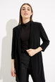 Woman wearing a black coat over a black turtleneck and patterned pants on a white background