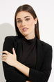 Woman wearing a black blazer against a white background