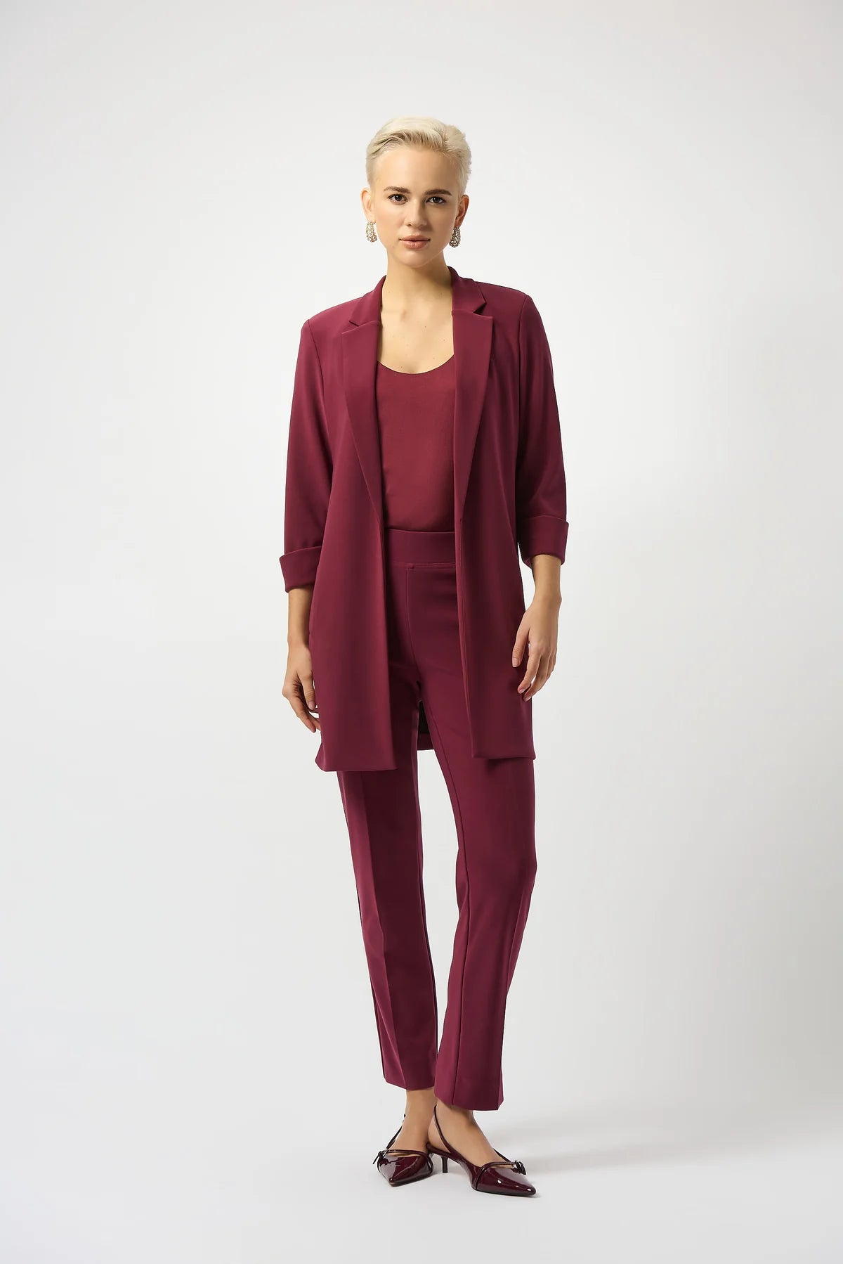 Woman wearing a burgundy suit on a white background