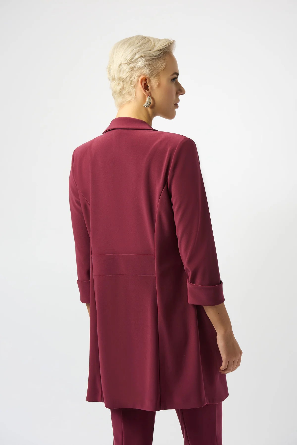 Woman wearing a burgundy coat on a white background