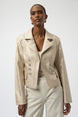 Woman wearing a beige jacket with a plain background