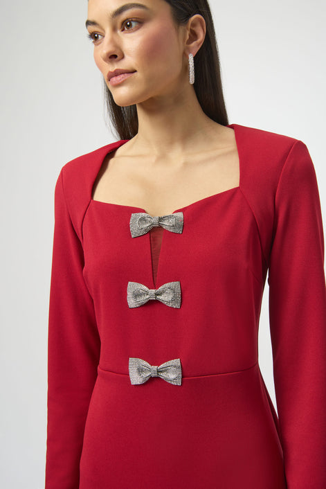 Red dress with silver bow details worn by a model on a plain background