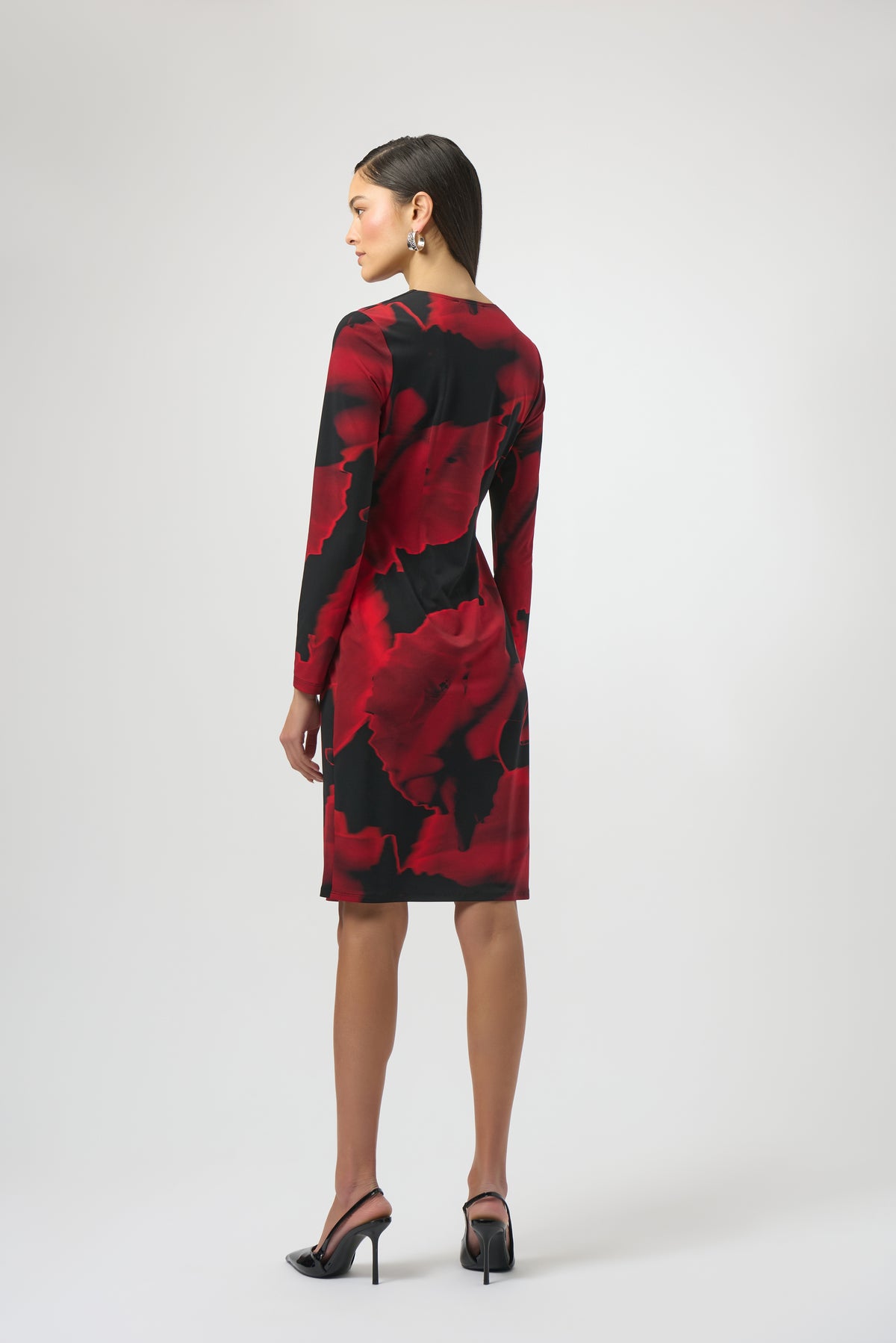 Woman wearing a red and black patterned dress on a white background