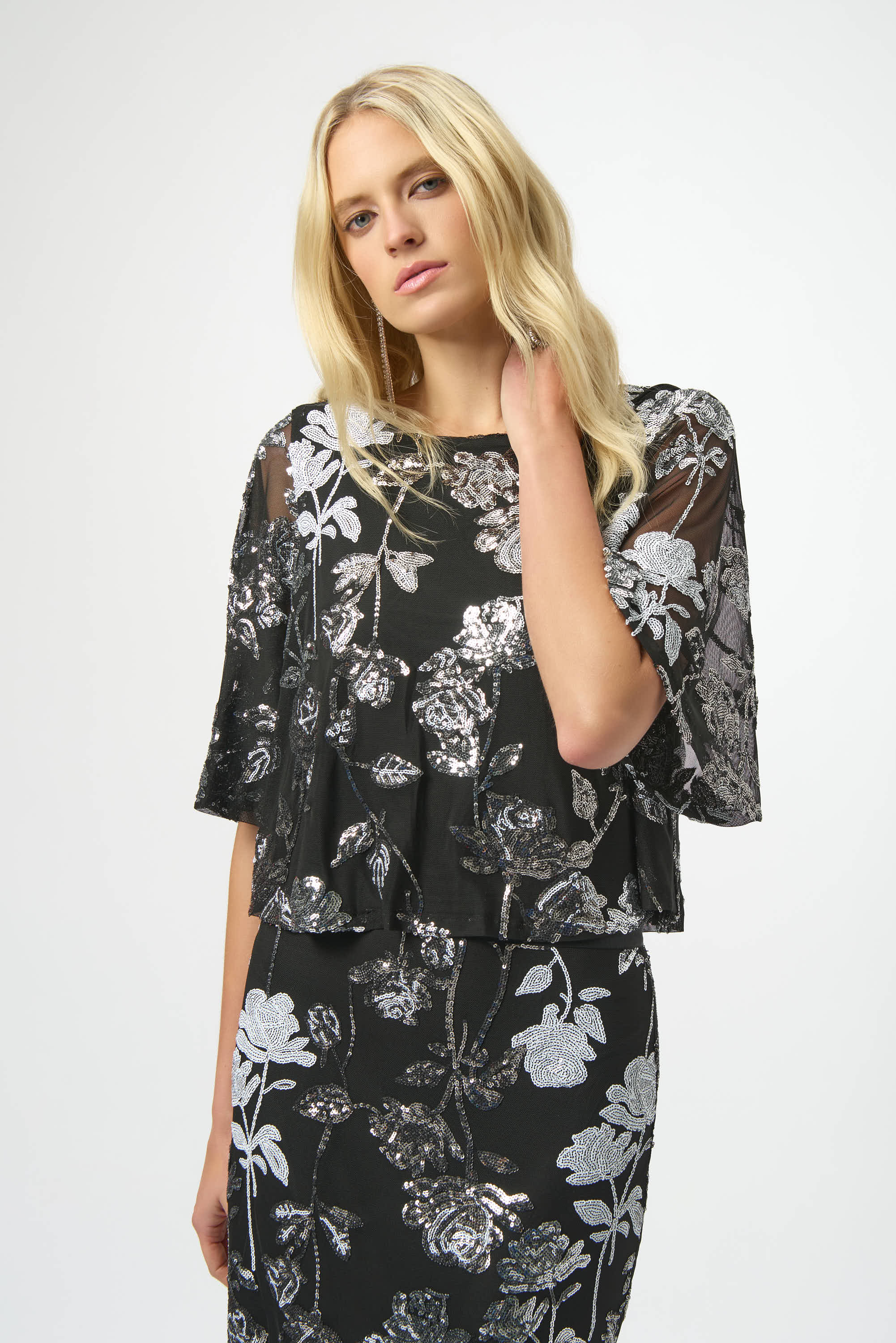 Woman wearing a black floral dress against a white background