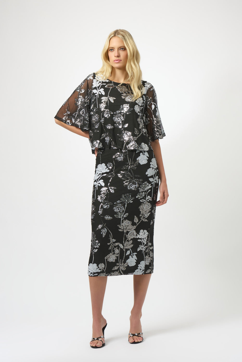 Woman wearing a black floral dress on a white background