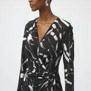 Woman wearing a black and white patterned dress on a plain background
