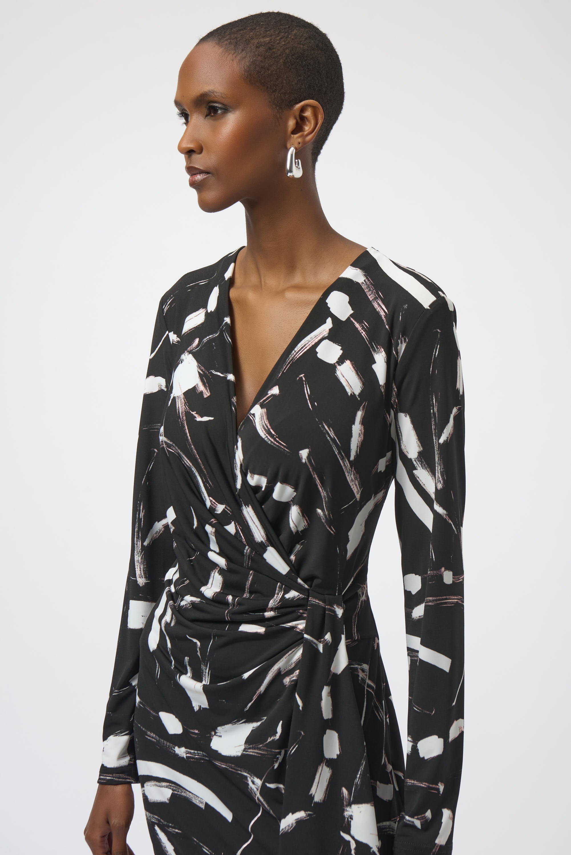 Woman wearing a black and white patterned dress on a plain background