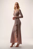 Woman wearing a long, flowing dress with a plain background