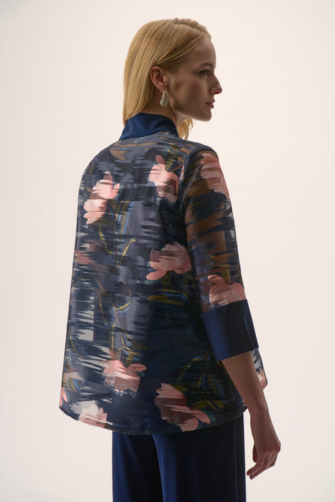 Woman wearing a floral patterned jacket with a plain background