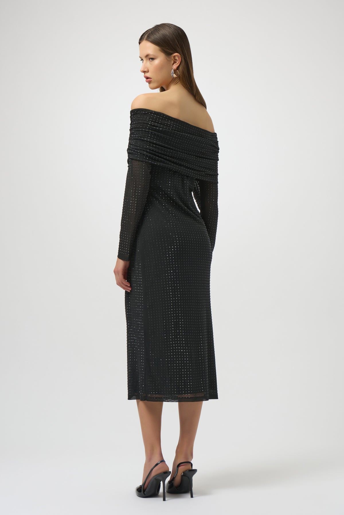 Woman wearing a black off-shoulder dress on a white background