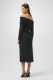 Woman wearing a black off-shoulder dress on a white background