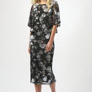 Woman wearing a black floral dress on a white background