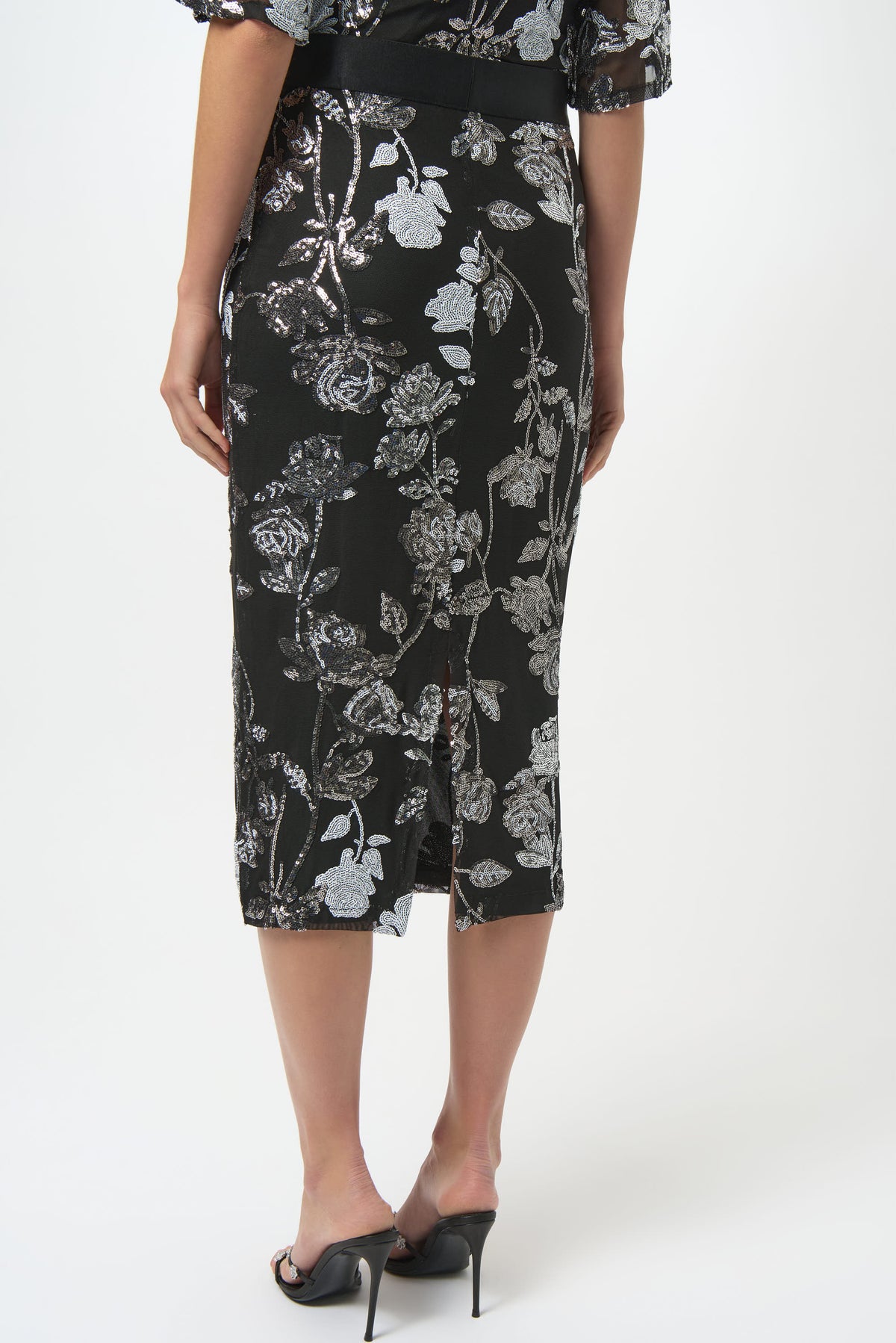 Woman wearing a black floral dress on a white background