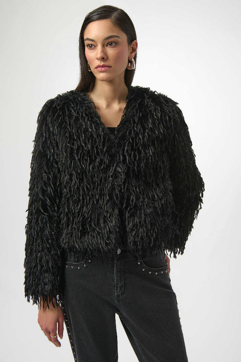 Woman wearing a black textured jacket against a white background