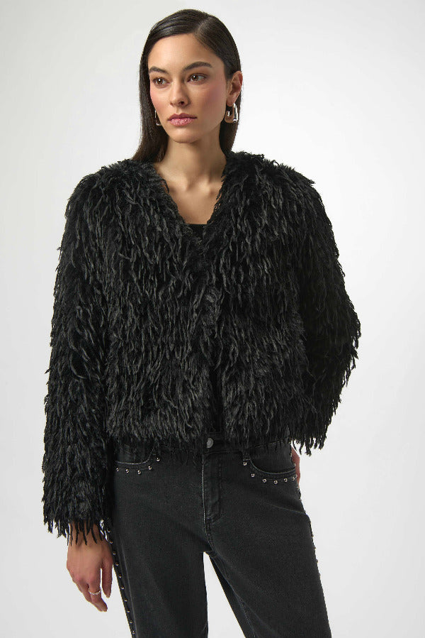 Woman wearing a black textured jacket against a white background