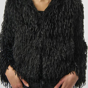 Black furry jacket worn by a model on a white background