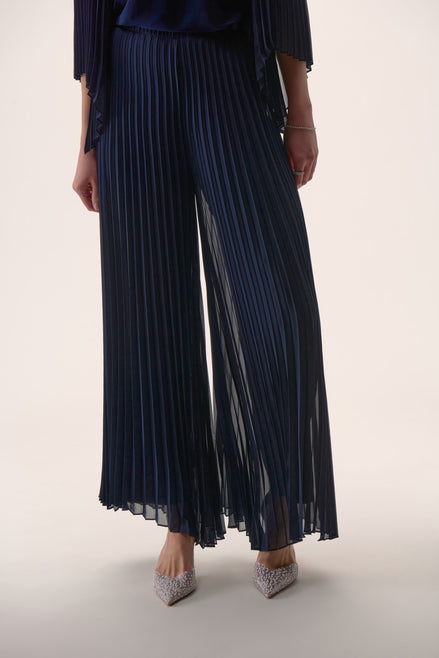 Navy pleated pants worn by a person on a light background