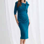 Woman wearing a teal dress against a white background