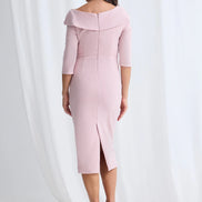 Woman wearing a pink off-shoulder dress with a slit on a white background