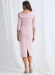Woman wearing a pink off-shoulder dress with a slit on a white background