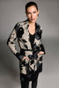Woman wearing a patterned coat with a gray background