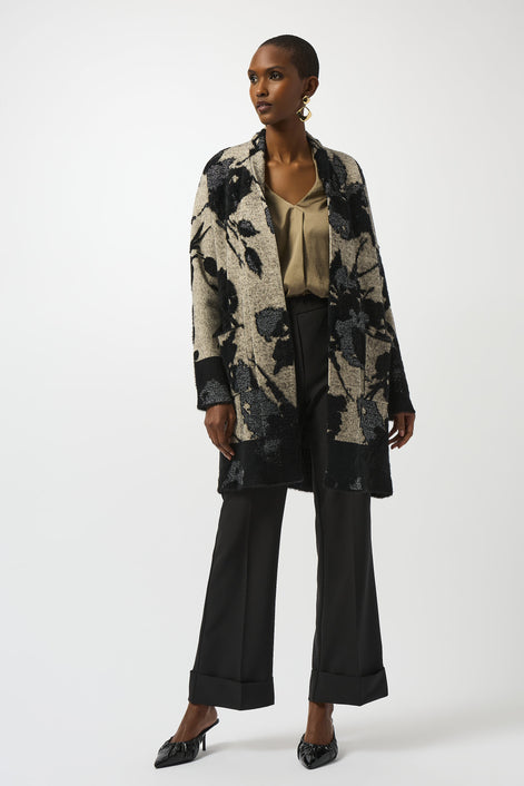 Woman wearing a floral coat and black pants on a white background